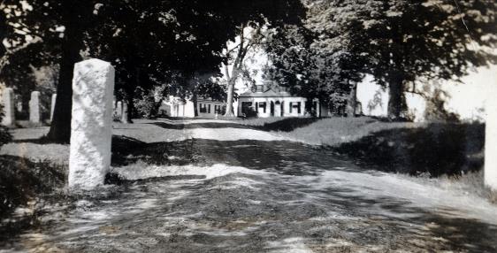 Historic house with stone marker and trees